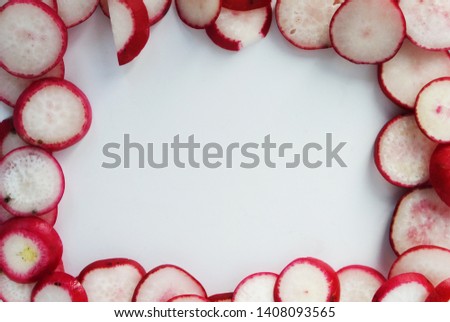 A picture of a background with sliced ​​radish pieces on a white background. Food photo. Top view. Frame of radish slices.
