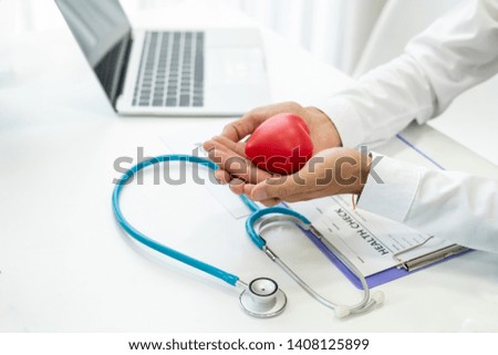 Male doctor holding a red heart. Health care concept Heart disease treatment.