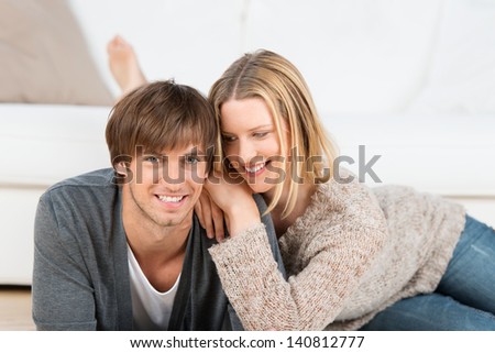 smiling couple at home lying on the floor, relaxing