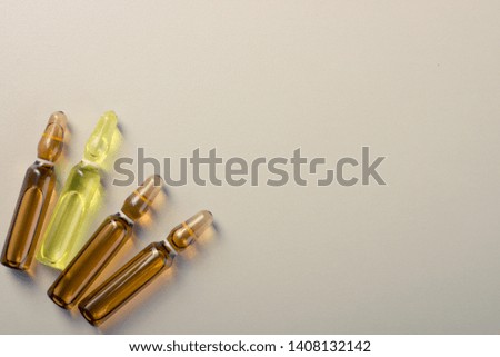 Pile of medicine ampoules and vitamin capsules on an abstract background. Healthcare, medical and pharmaceutical flatlay concept. Detailed close up studio shot with copy space. Toned