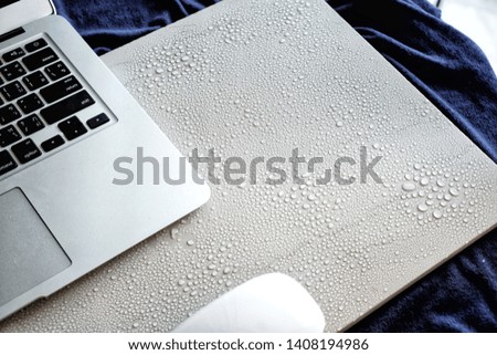 Drops of water on the work table. There is a laptop on a white marble pattern.  Like work problems  That comes in many beautiful views