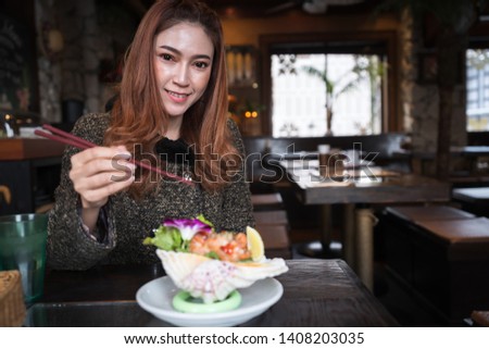 woman eating salmon sashimi spicy salad in the restaurant