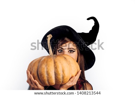 Beautiful young woman in black witch costume with hat over white background.