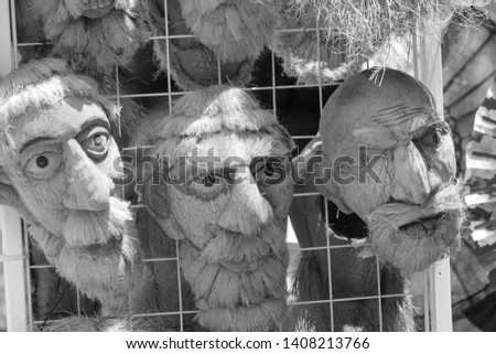 Traditional Asian coconut shell masks in black and white.