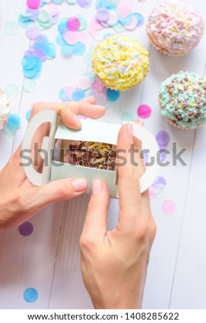 hands carefully pack present or goods cake pastel colors