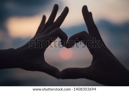 Close up, Heart made by hands on a sunset.