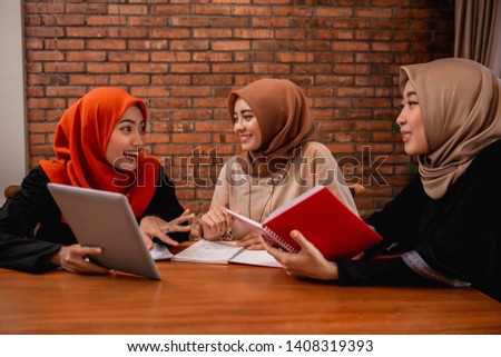 Hijab women chatting with friends about university assignments must be completed