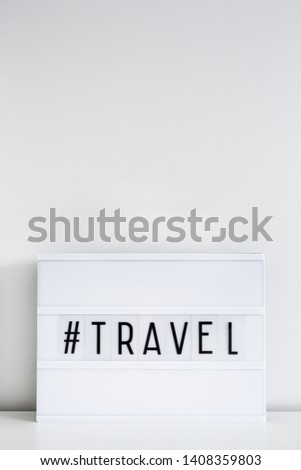 retro light box with travel hash tag and copy space over white wall background