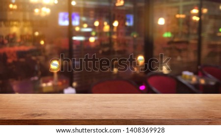 Empty wood table top on abstract blurred restaurant and nightclub lights background - can be used for display or montage your products