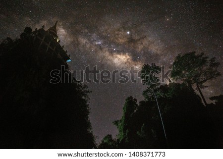 The sky full of night stars and the Milky Way floating above the mountains of Thailand