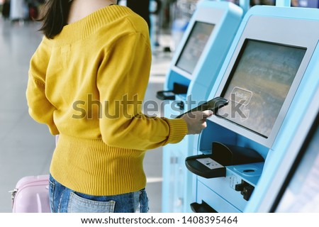 Traveler using a self check-in machine kiosk service at airport, Technology and smart application to confirm flight booking details, Travel concept. Royalty-Free Stock Photo #1408395464