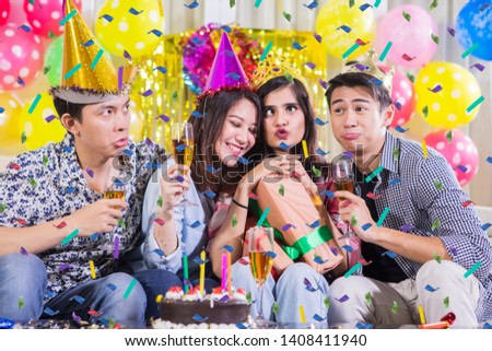 Group of cheerful young people taking selfie picture together with funny expression at a birthday party