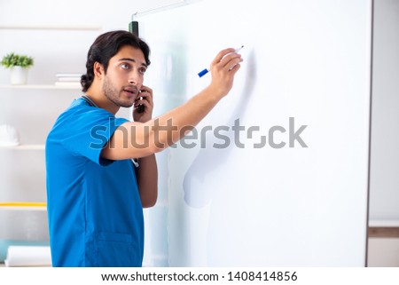 Young male doctor in front of whiteboard 
