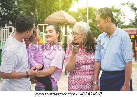 Picture of three generation family wearing sportswear while standing in the park