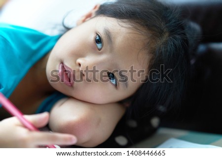Girl lie down for writing notebook on floor