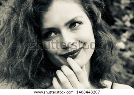 A cute, curly-haired, smiling young woman black and white portrait Royalty-Free Stock Photo #1408448207