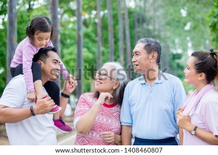 Picture of extended family talking each other after doing exercise together in the park