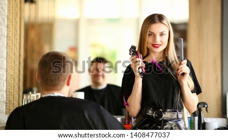 Woman Hairdresser Showing Razor and Comb to Client. Female Hairstylist Holding Electric Shaver and Hairbrush for Styling Male Haircut. Professional Stylist Using Shave for Hairdo in Salon