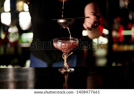Alcohol cocktail on the bar. Bartender prepares an alcoholic cocktail