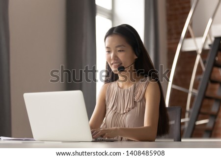 Smiling asian businesswoman receptionist customer care service support manager wear headset working on laptop, korean helpline operator secretary make conference video call consulting client online Royalty-Free Stock Photo #1408485908