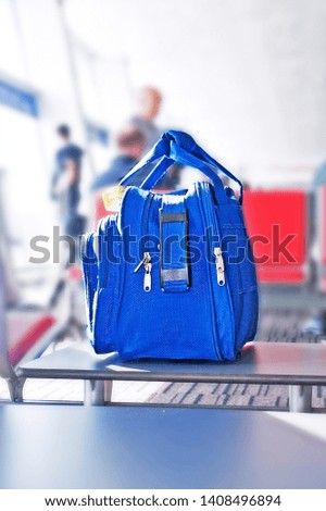 blue bag - hand luggage is on the seat at the airport
