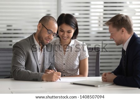Happy proud mixed ethnicity young family couple customers sign loan investment contract sale purchase prenup agreement meeting bank manager agent make financial mortgage deal buying house insurance Royalty-Free Stock Photo #1408507094