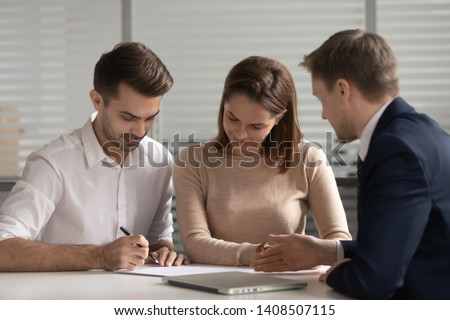 Young family couple customers clients sign paper mortgage investment contract sale purchase agreement take bank loan buying insurance service meeting broker agent make financial business leasing deal