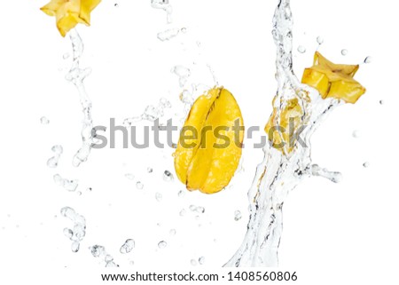 whole ripe exotic star fruit and slices with water splash and drops isolated on white