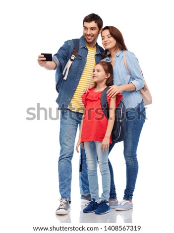 family, tourism and travel concept - happy smiling mother, father and little daughter with backpacks taking selfie by smartphone over white background
