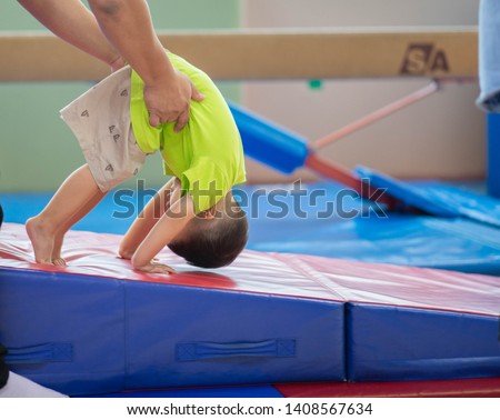 Little toddler boy working out at the indoor gym excercise