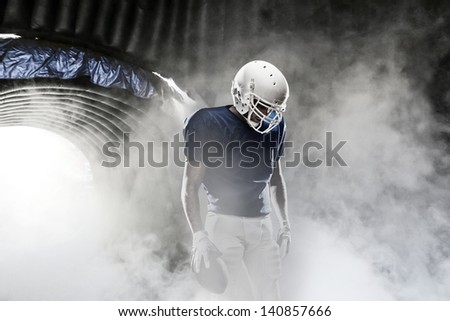 Football player, leaving a smoky tunnel, ready to get on the field Royalty-Free Stock Photo #140857666