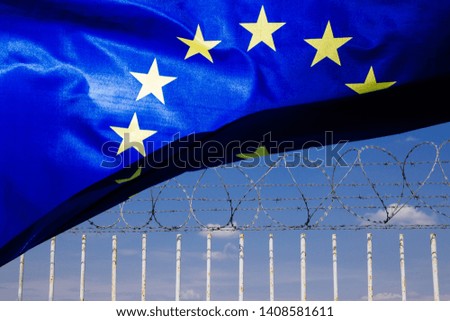 Barbed wire fence. Immigration themed image with european flag. 