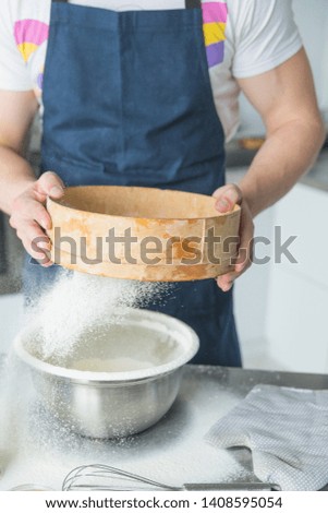 man hands sifting flour with flour filter