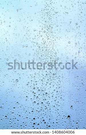 Raindrops on the glass, dark blue sky background outside the window.