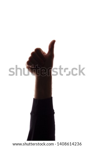 Hand of a young man with a raised finger, like and approval - silhouette concept abstraction