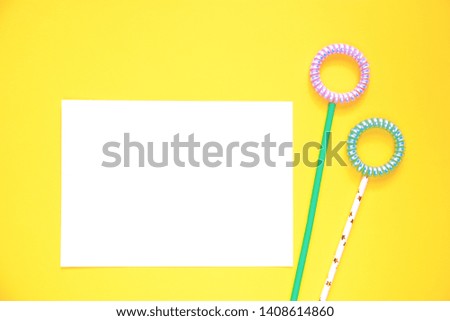 flat lay flowers of spiral hair bands and tubes, blank copy space letter on a yellow background copy space, abstract background