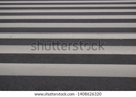 White lines and crosswalk on asphalt texture background