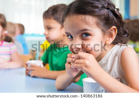 Cute little children drinking milk at daycare Royalty-Free Stock Photo #140863186