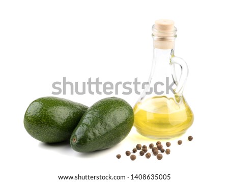 Sliced avocadoes and oil in bowl and bottle on white background top view, copy space. Vegetarian oils concept