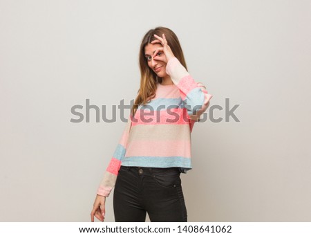 Young russian girl confident doing ok gesture on eye