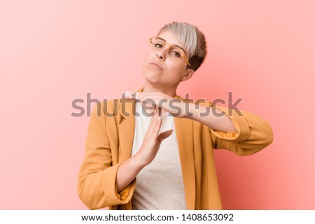 Young caucasian woman wearing a casual business clothes showing a timeout gesture.