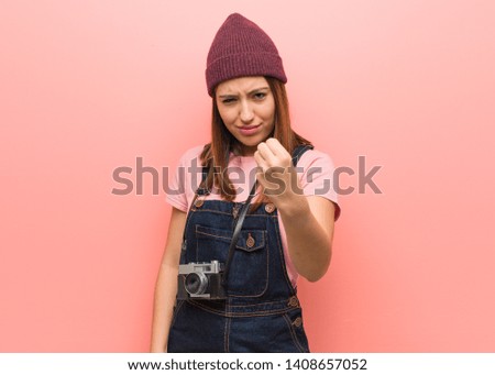 Young cute photographer woman showing fist to front, angry expression