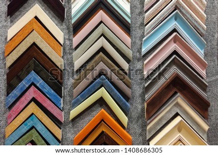 A collection of solid wood photo picture frame corner samples are displayed on a table.