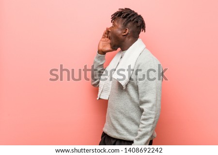 Young fitness african black man shouting and holding palm near opened mouth.