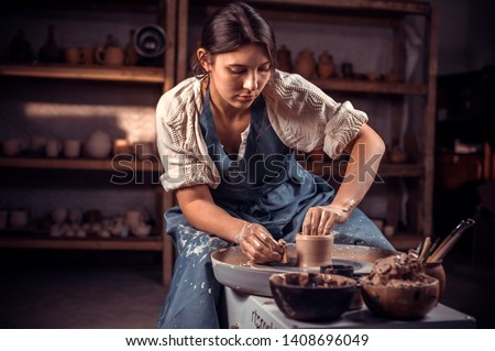 Charming craftsman enjoying pottery art and production process. Making ceramic dishes. Royalty-Free Stock Photo #1408696049