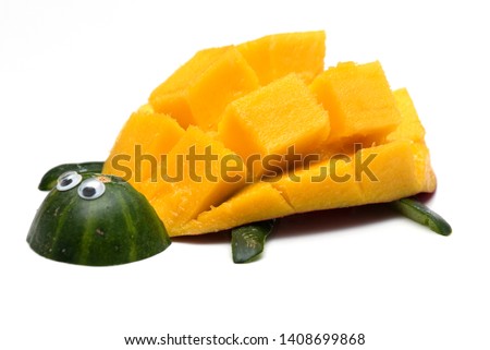 Food art creative concepts. Turtle made of yellow mango and  cucumber skin. Funny dessert for children. Cute animal made of fruit isolated on a white background.