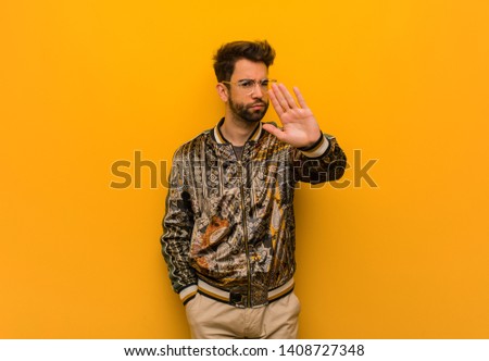 Young cool man putting hand in front