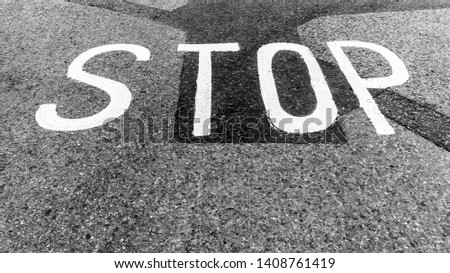 Stop sign painted on asphalt road surface