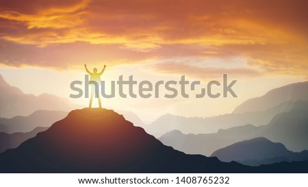 Man standing on edge of mountain feeling victorious with arms up in the air. Success, life goals, achievement concept. Royalty-Free Stock Photo #1408765232