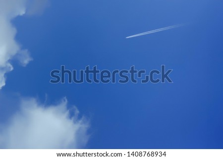 Beautiful bright blue sky with with a flying plane. clouds. picturesque colorful